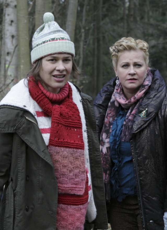 Zwei Frauen in Winterkleidung stehen im nebligen Wald