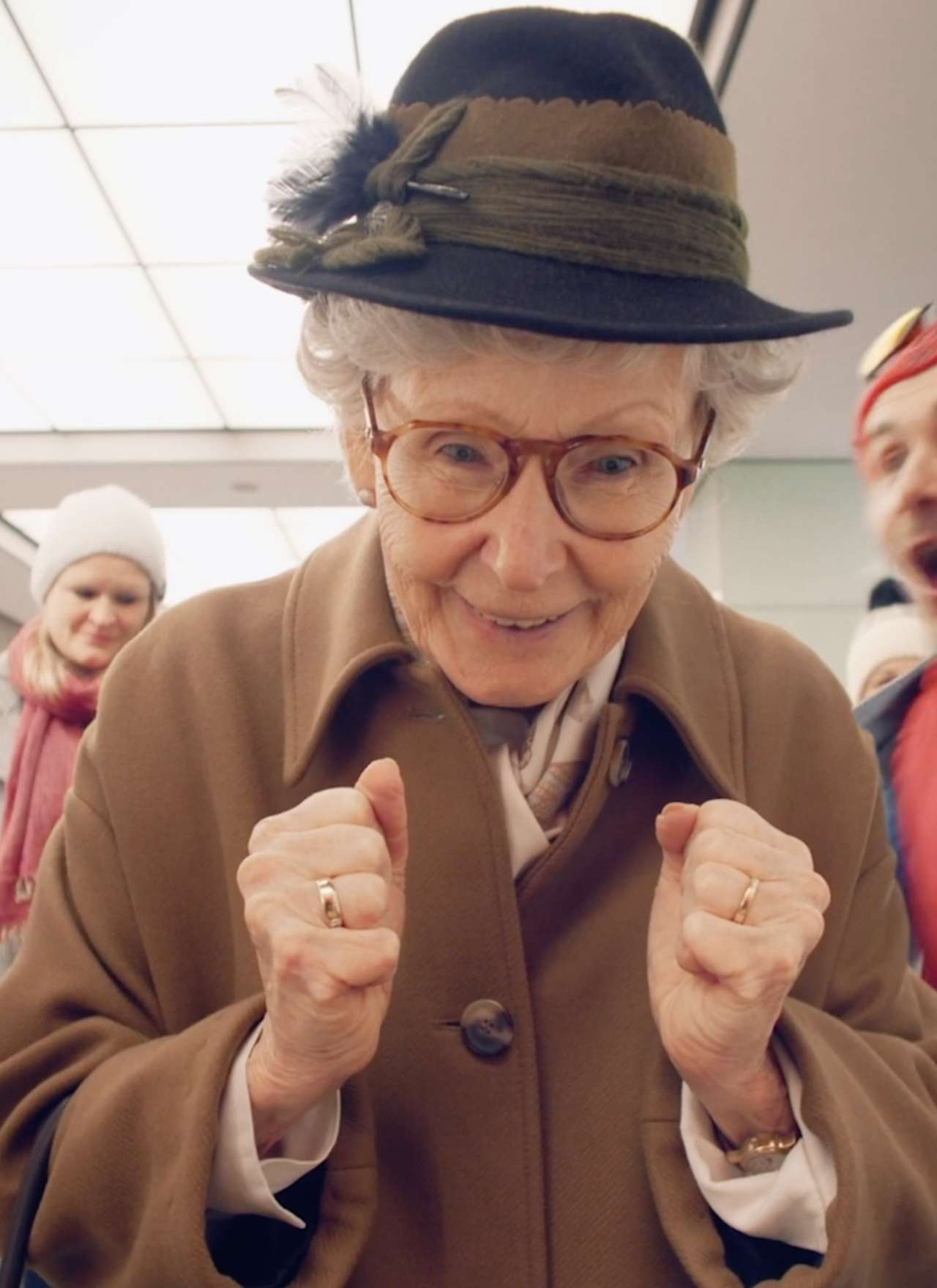 Ältere Dame mit Hut freut sich