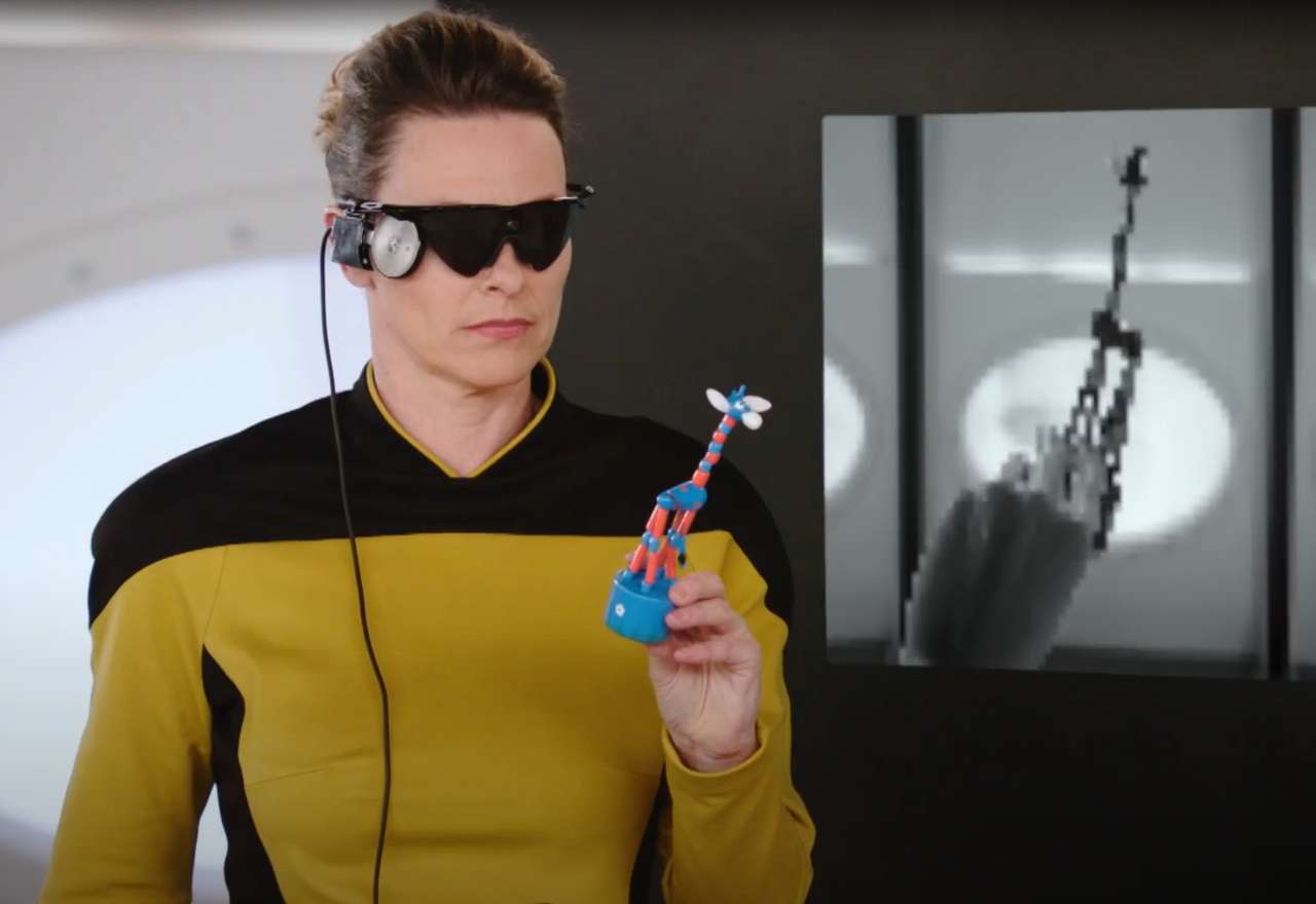 Anja Reschke mit schwarzer Brille und Spielzeuggiraffe